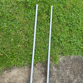 Two silver coloured curtain rods 
