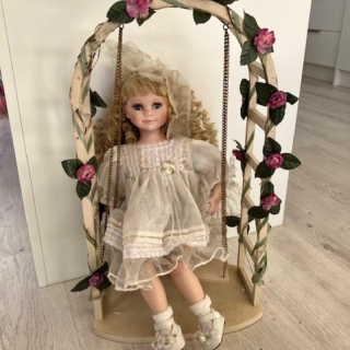 Porcelain doll on a swing